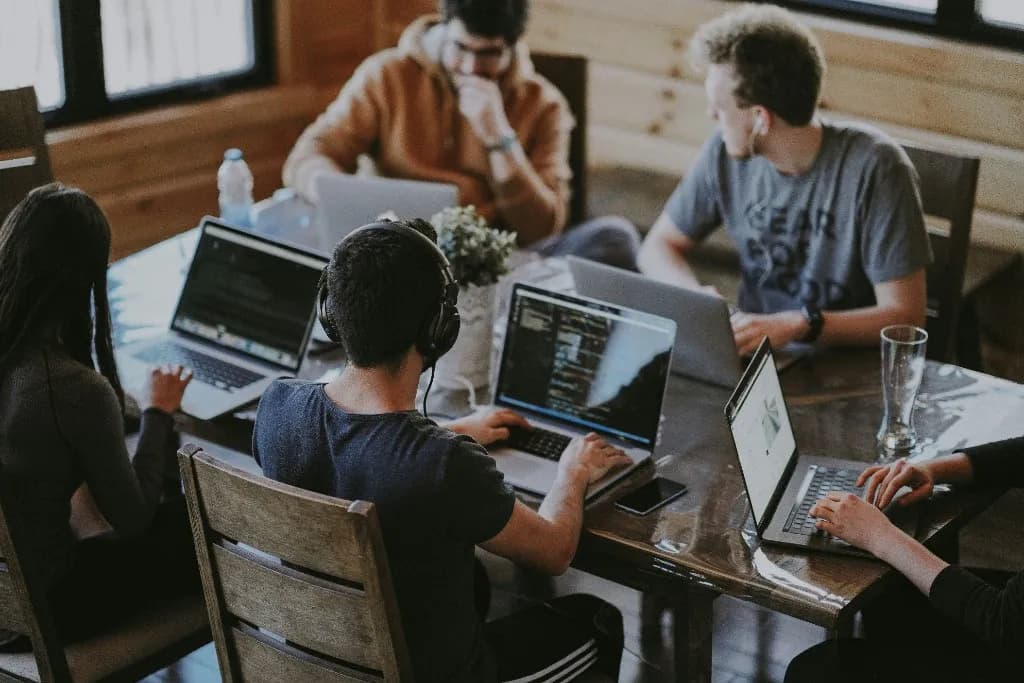 Engineers collaborating at laptops in a shared workspace
